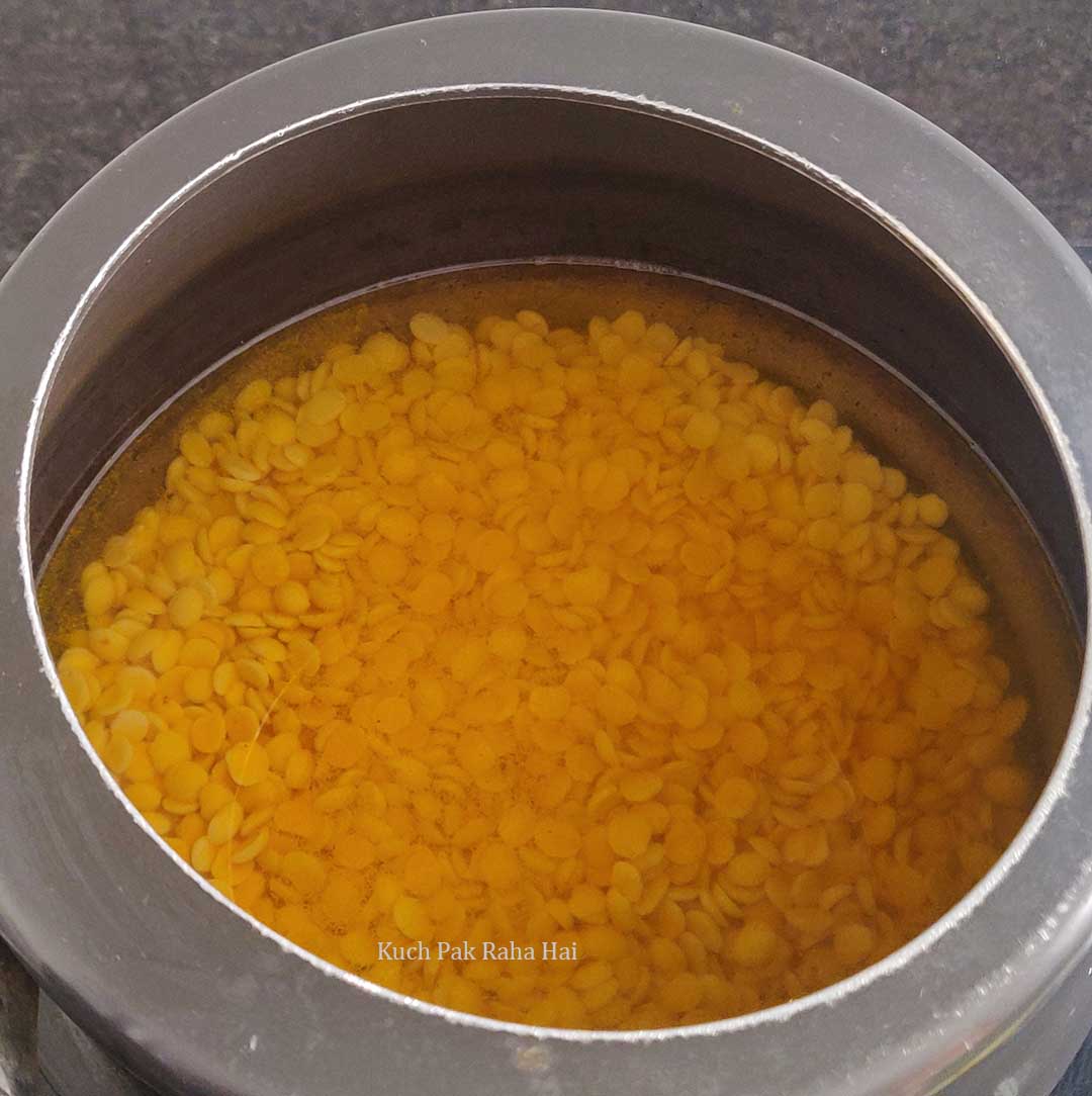 Cooking dahl in pressure cooker with salt and turmeric.