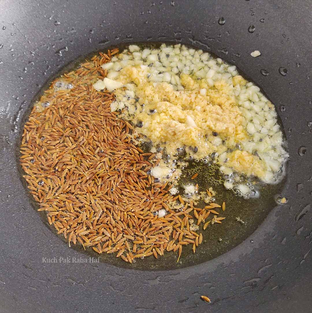 Sautéing cumin ginger garlic in oil.