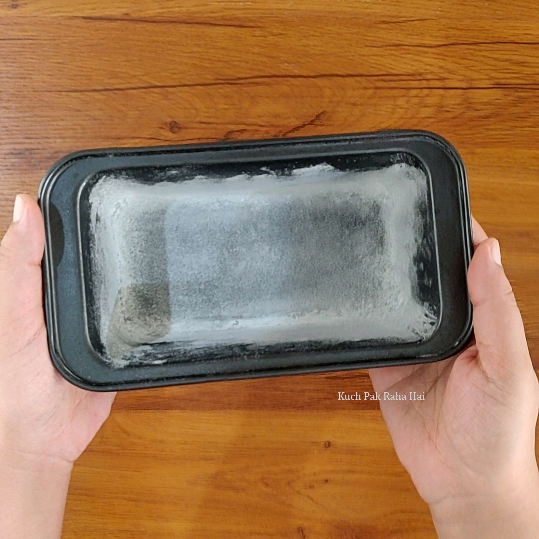 Preparing loaf tin for zebra cake.