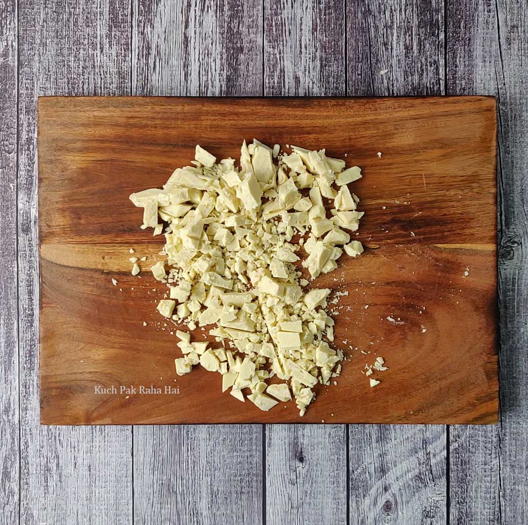 Chopped white chocolate on chopping board.