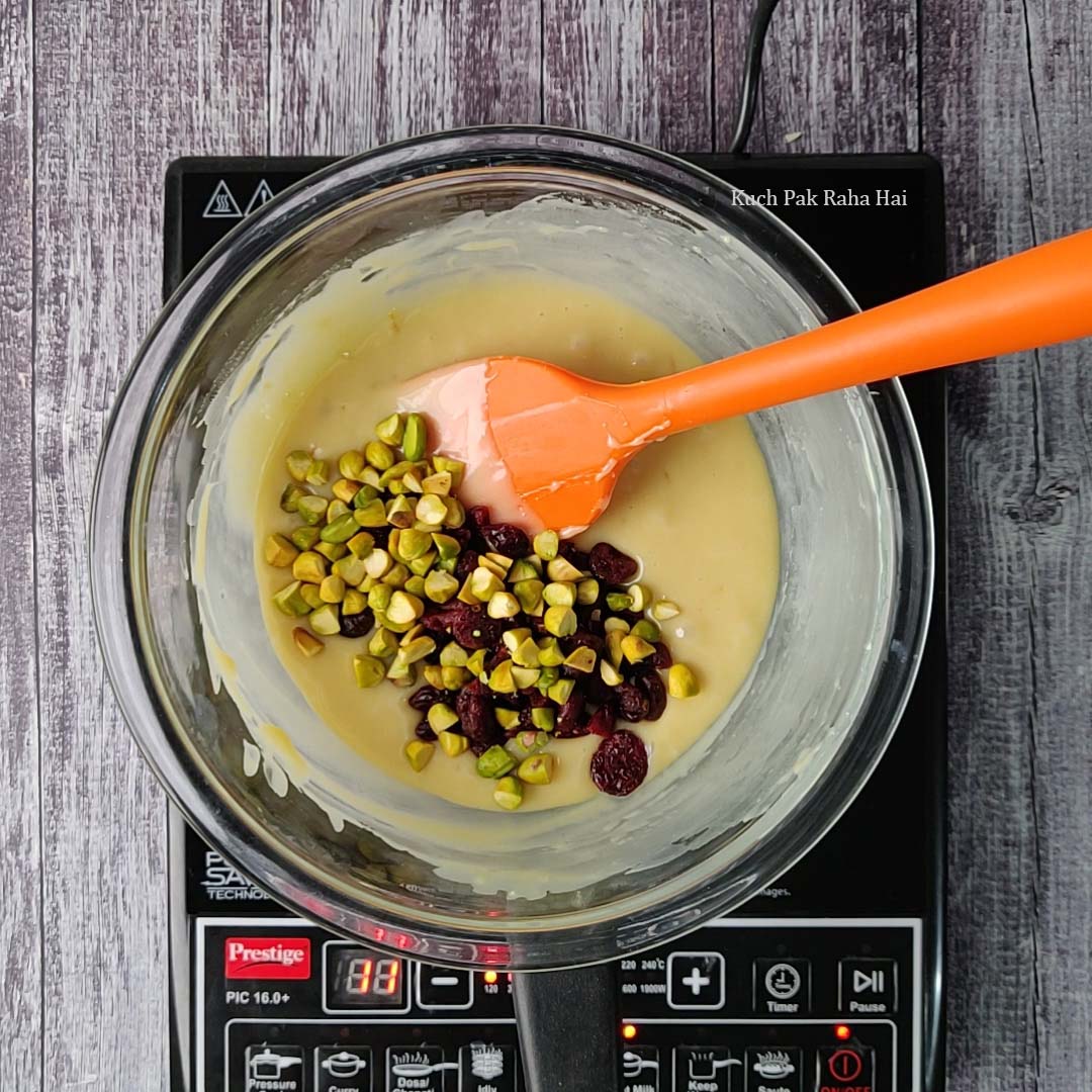 Adding cranberries and chopped pistachios to the fudge mixture.