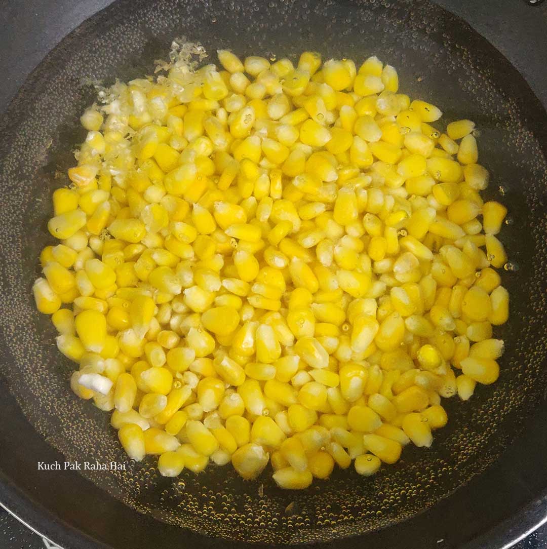 Boiling sweet corn kernels.