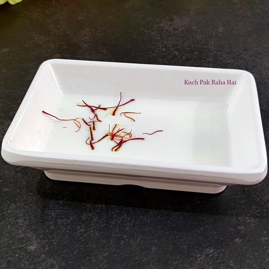 Soaking saffron strands in milk.