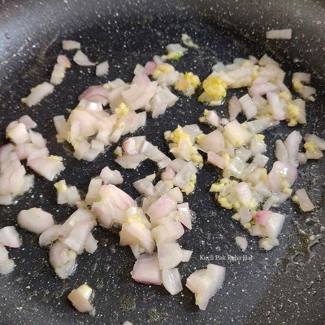 Sautéing onion and garlic in a pan.