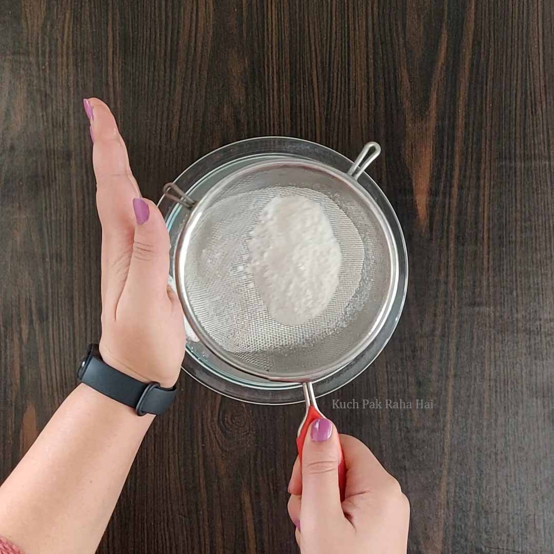 Sieving dry ingredients for jam cookies.