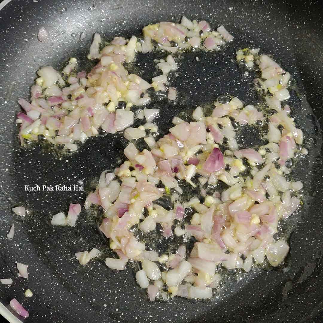Sautéing onion and garlic in a pan.