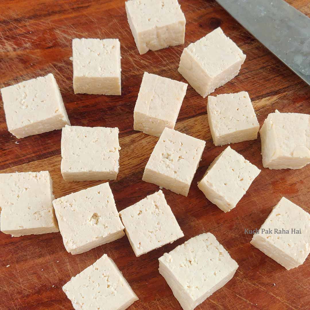 Cutting tofu block into cubes.