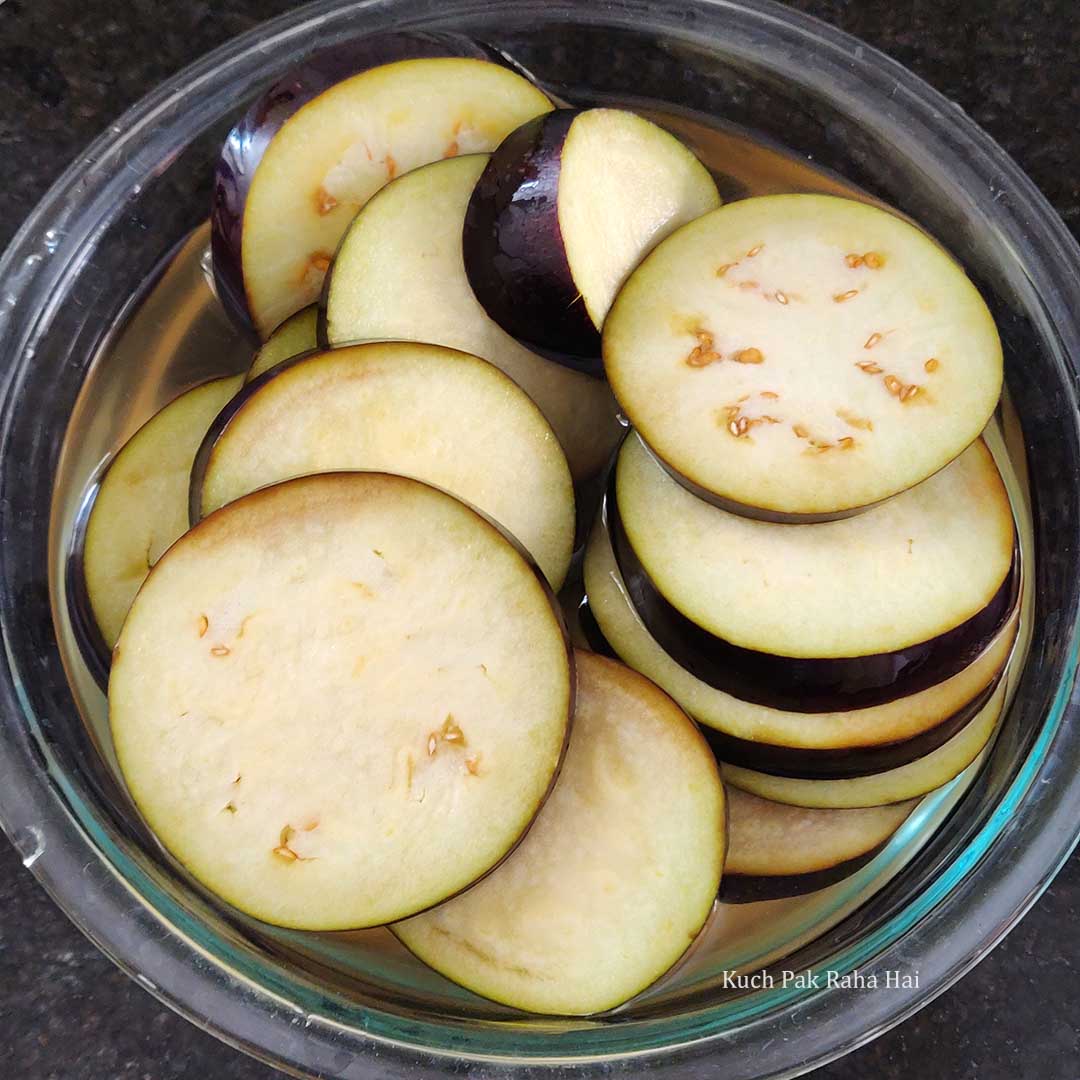 Soaking eggplant slices in salt water.