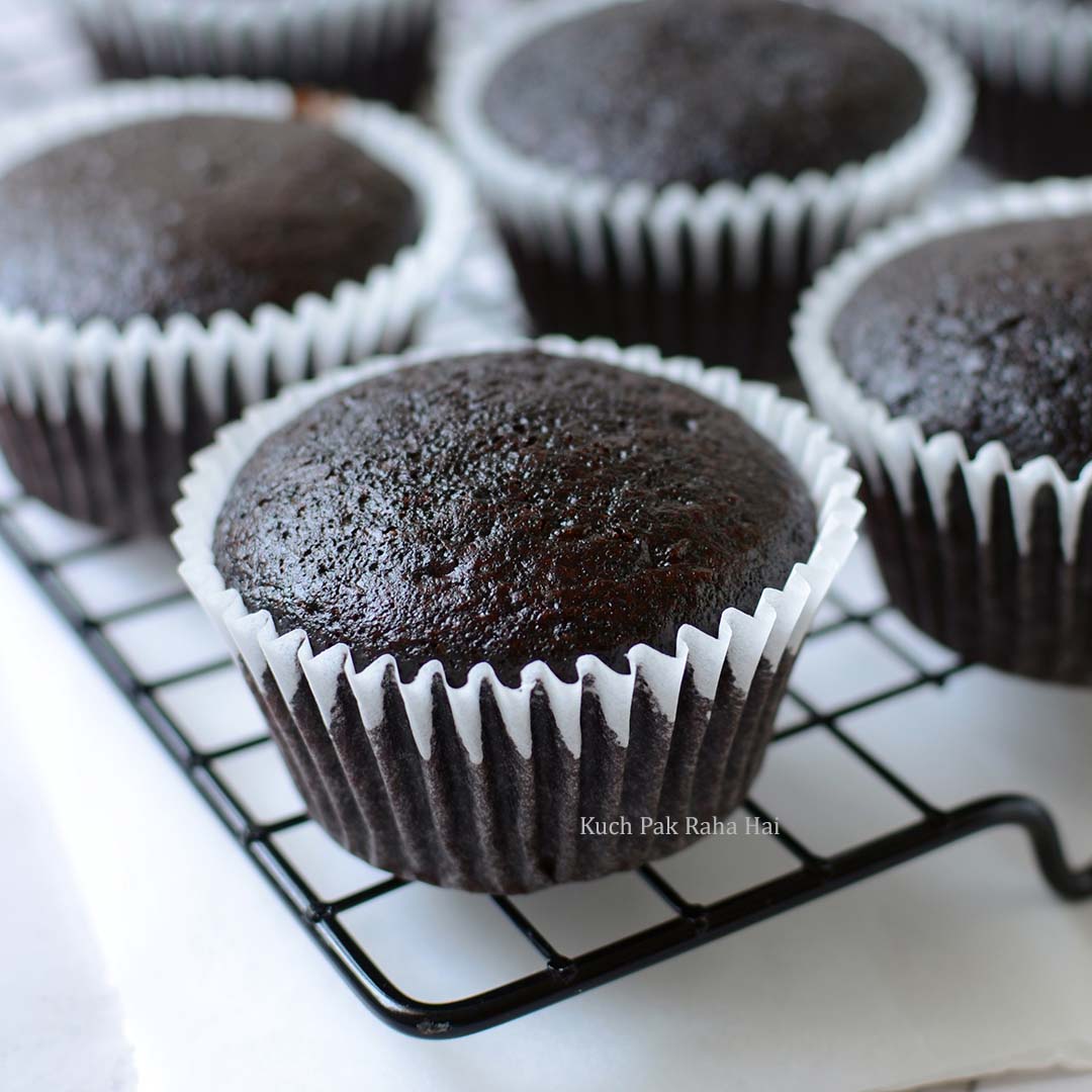 Eggless chocolate cupcakes cooling on wire rack.