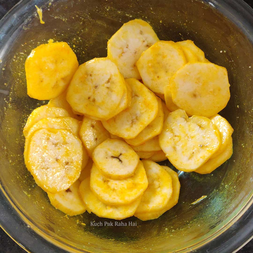 Adding salt & oil to sliced banana.