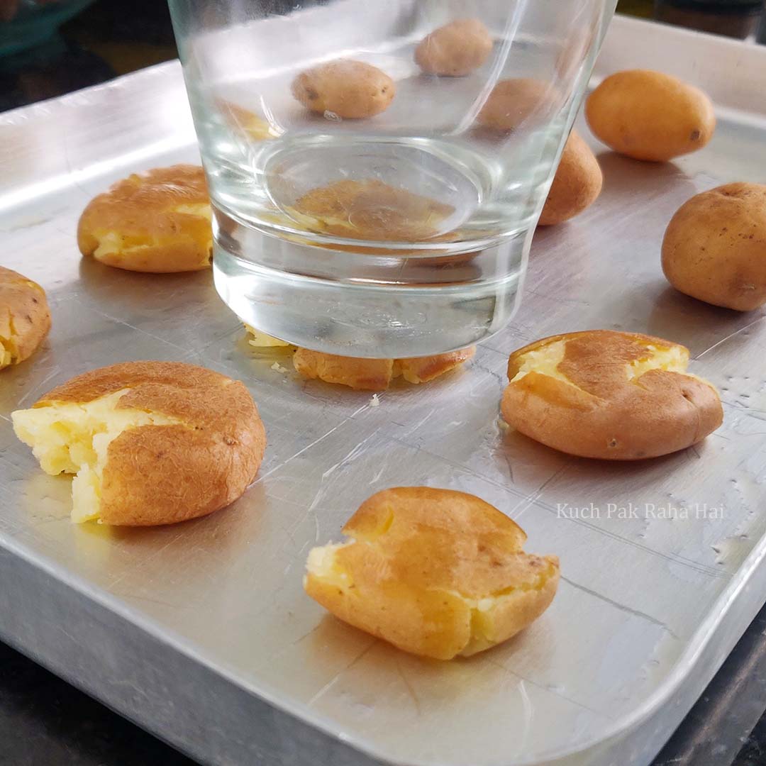 Smashing potatoes with back of a glass.