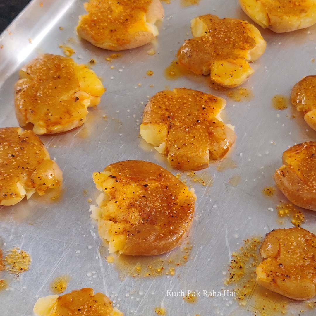 Applying spiced olive oil over smashed potatoes.