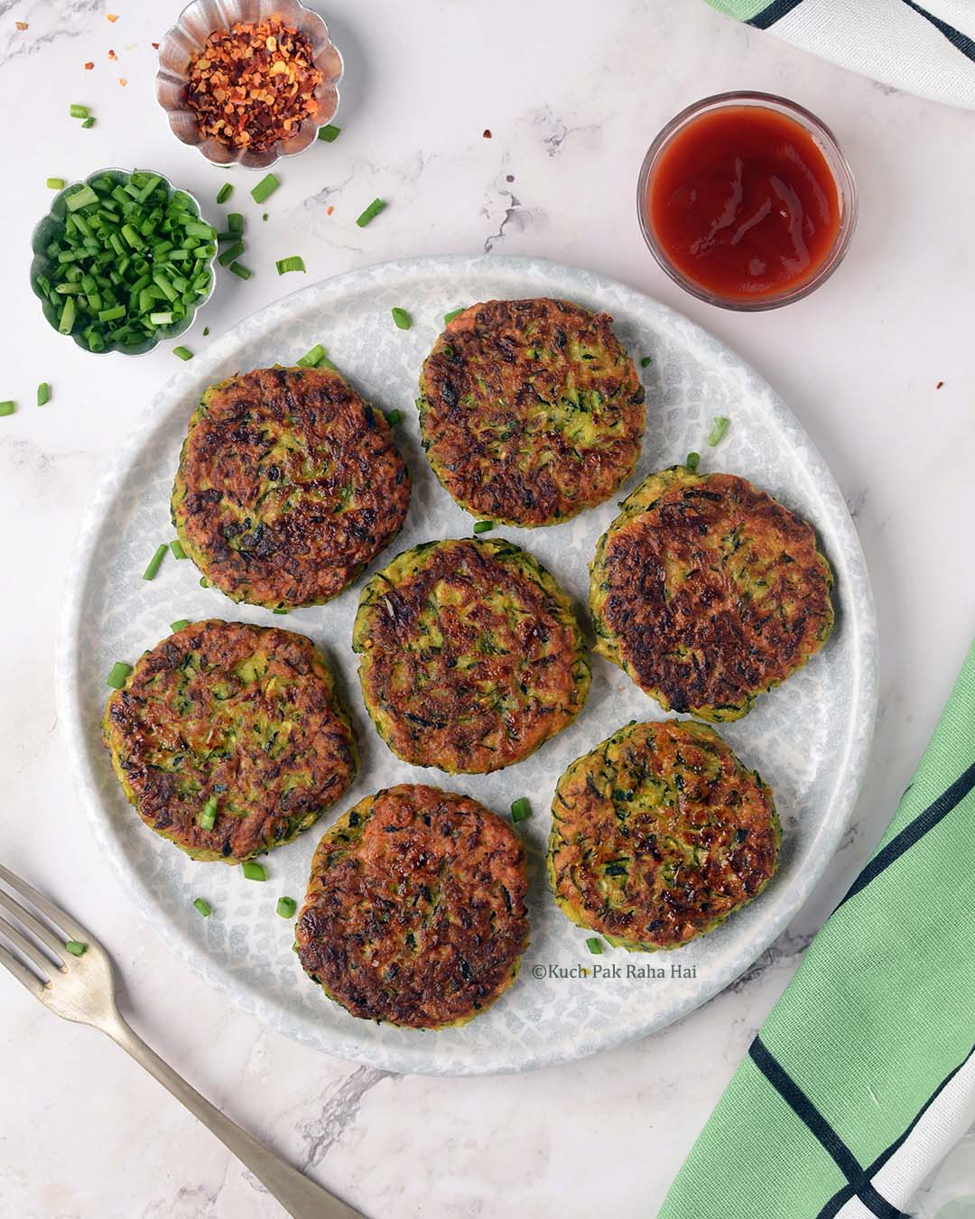 Vegan zucchini fritters served with ketchup & chopped scallions