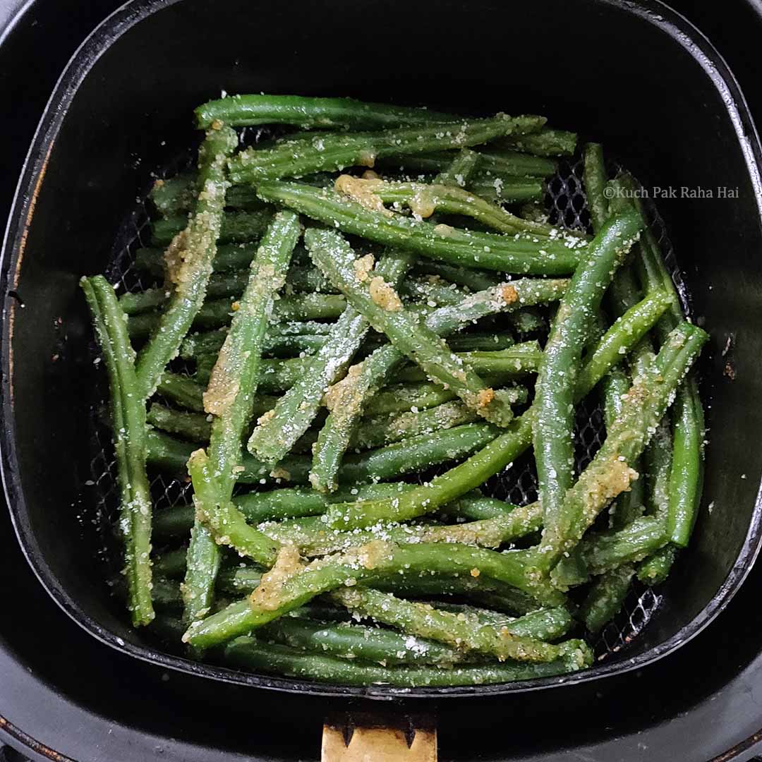 Green Beans in air fryer basket.