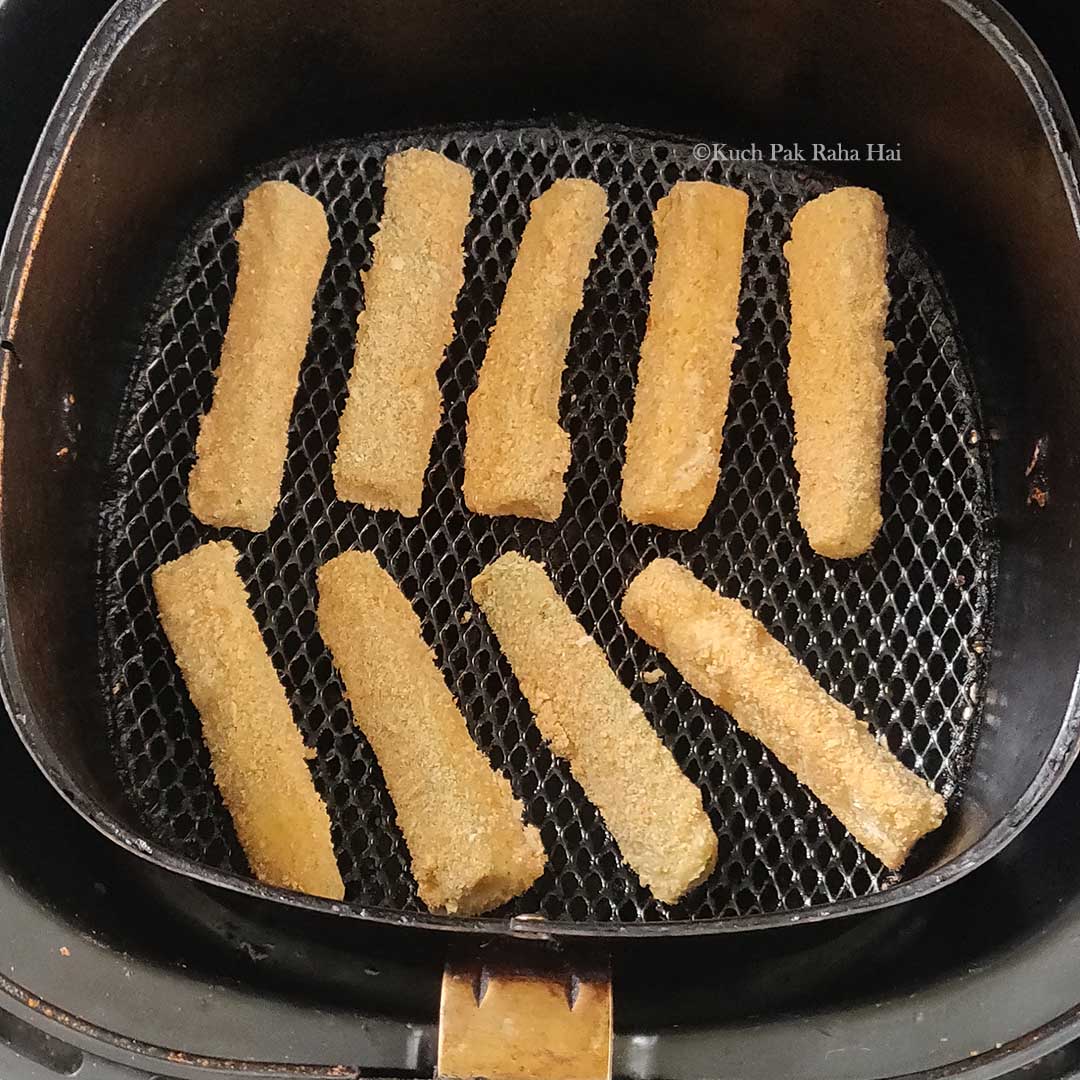 Raw zucchini fries in air fryer (before cooking).