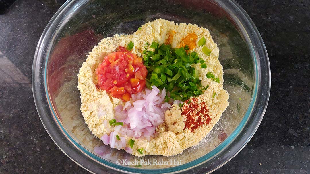 Chickpea flour, spices & vegetables in a bowl.