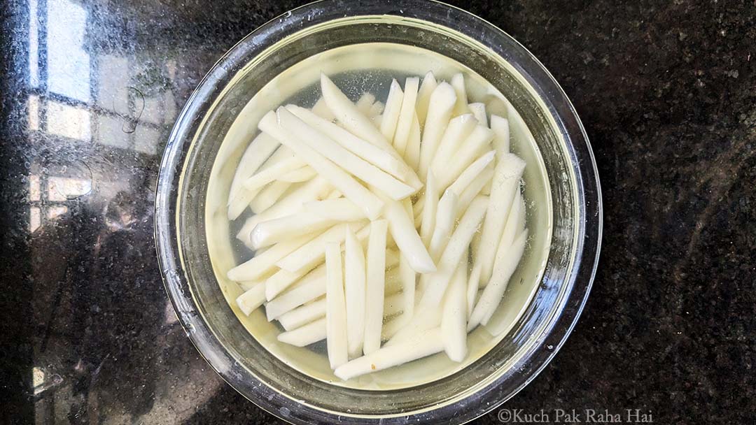 Soaking potato fries in water.