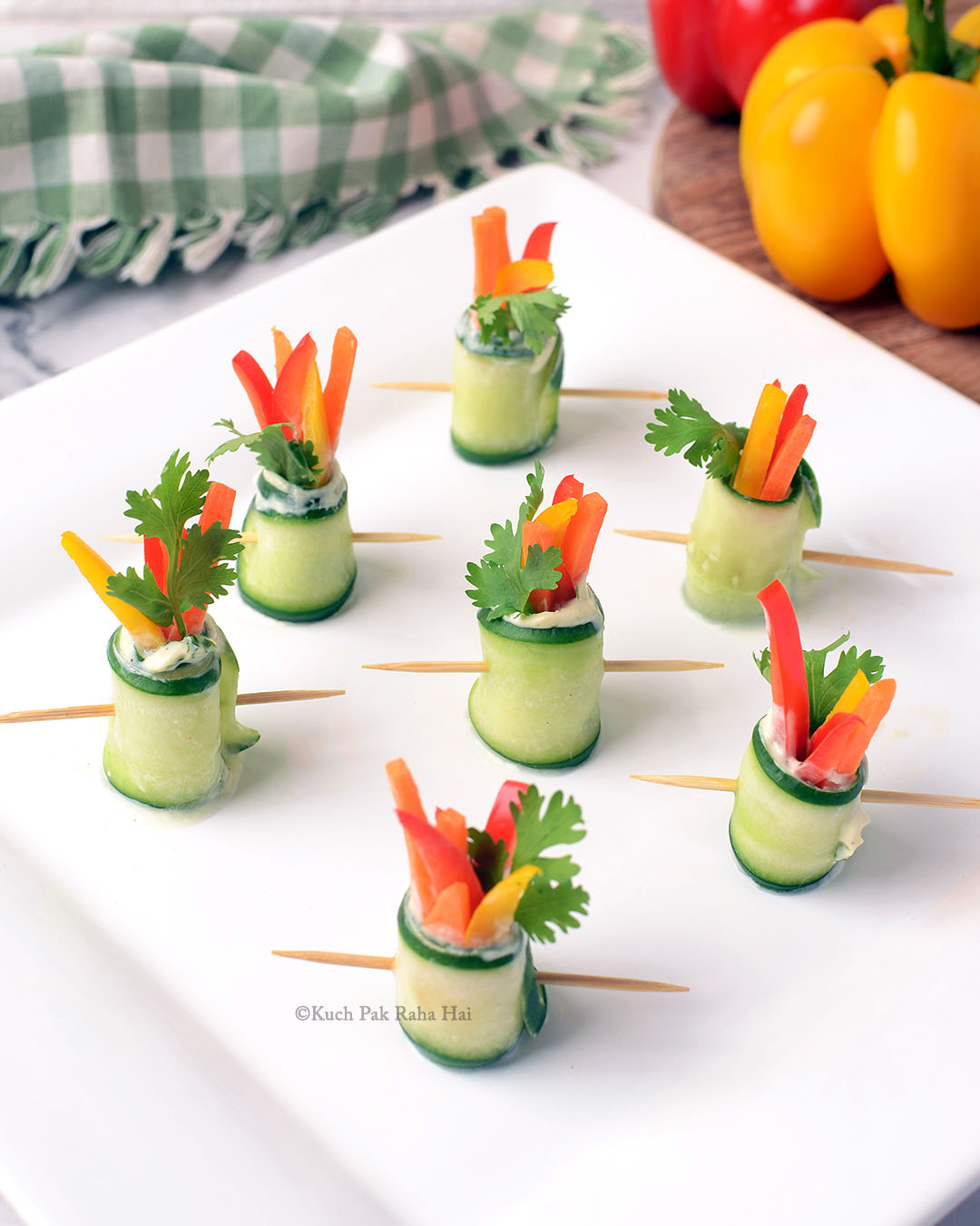 Cucumber rolls with cream cheese carrots bell peppers.