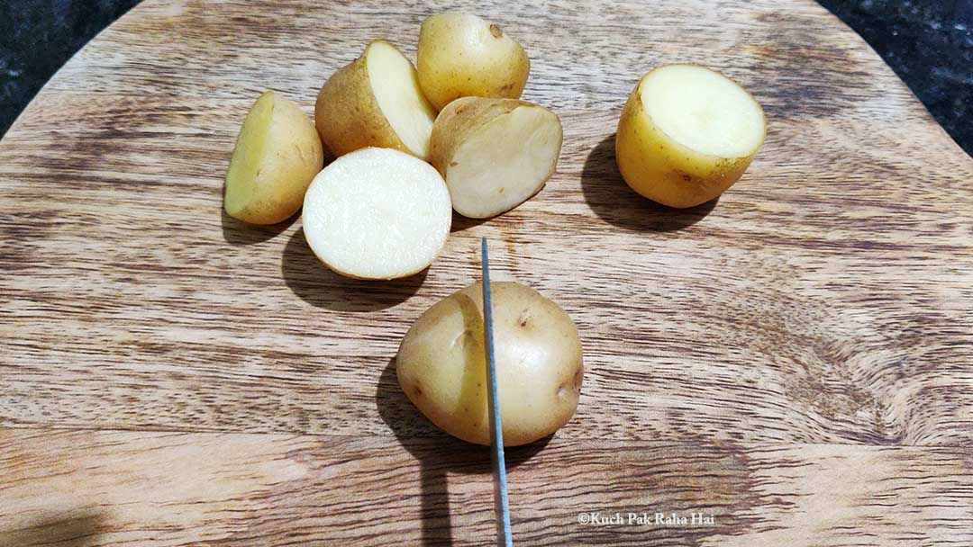 Chopping mini potatoes.