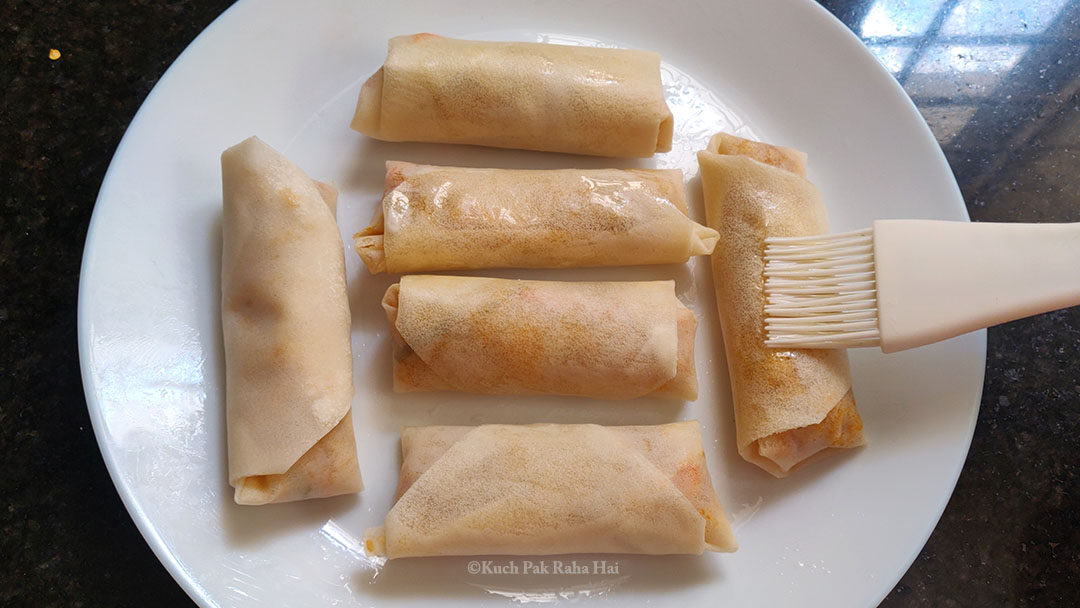 Brushing oil on spring rolls.