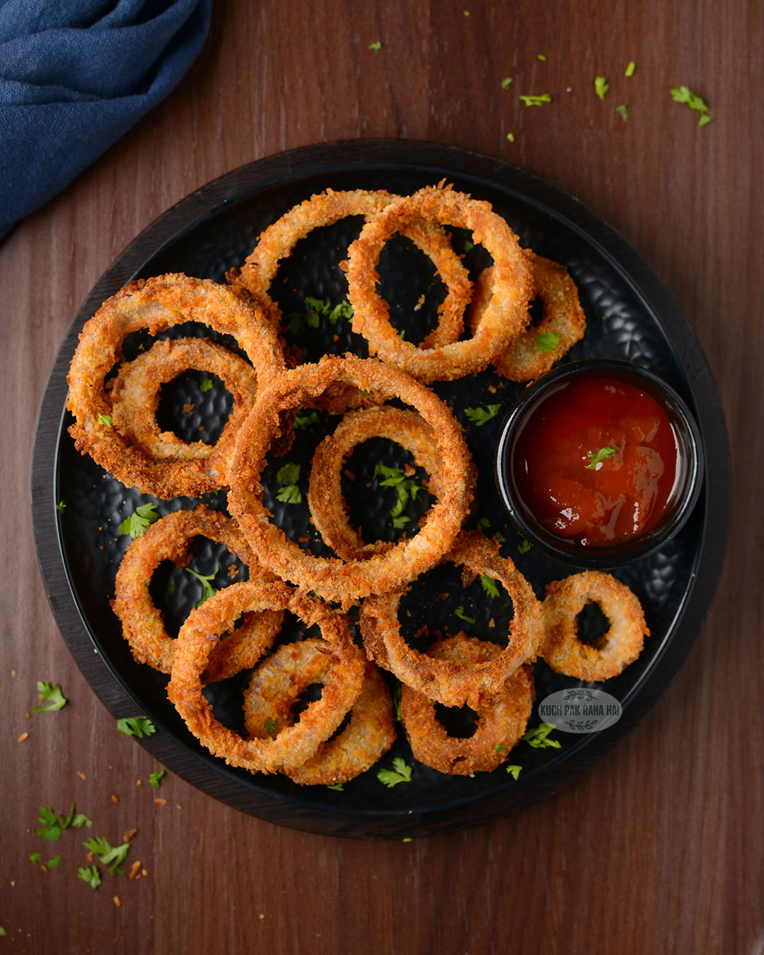 Air fried onion rings served with ketchup.