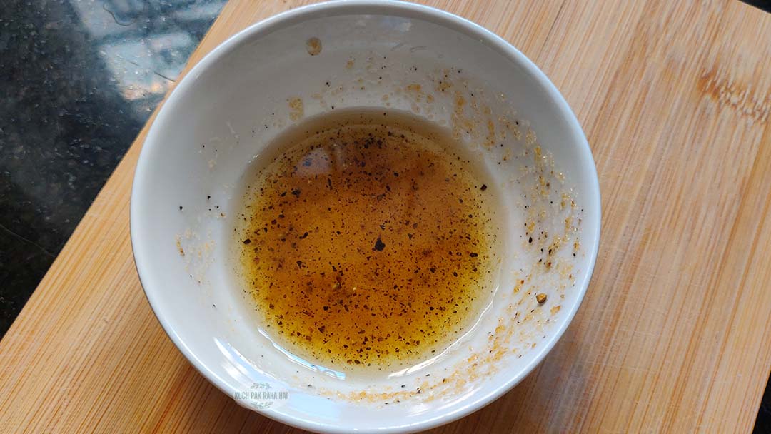 Mixing oil and seasoning in a bowl.