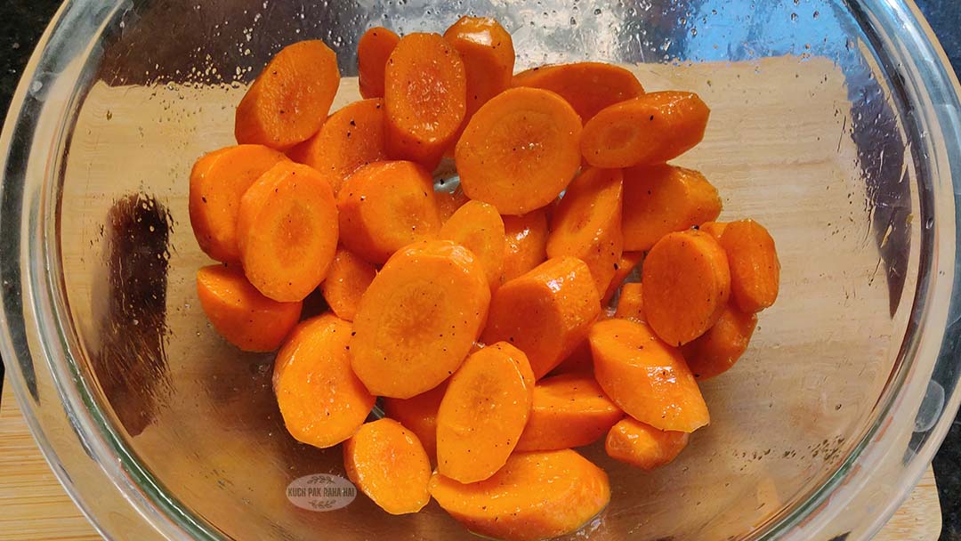 Tossing chopping carrots with oil.