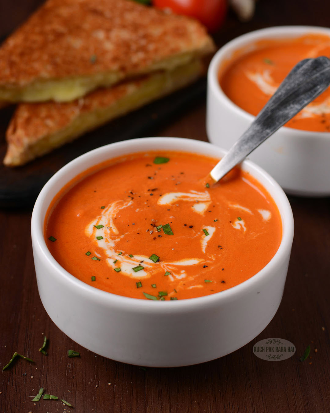 Roasted tomato soup served with grilled cheese sandwich.