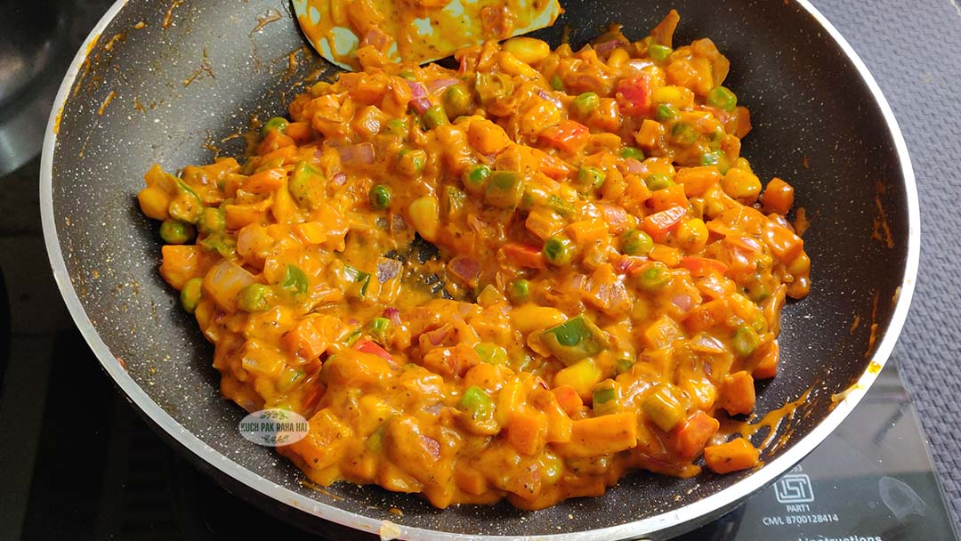 Adding pizza sauce and seasoning to vegetable filling.