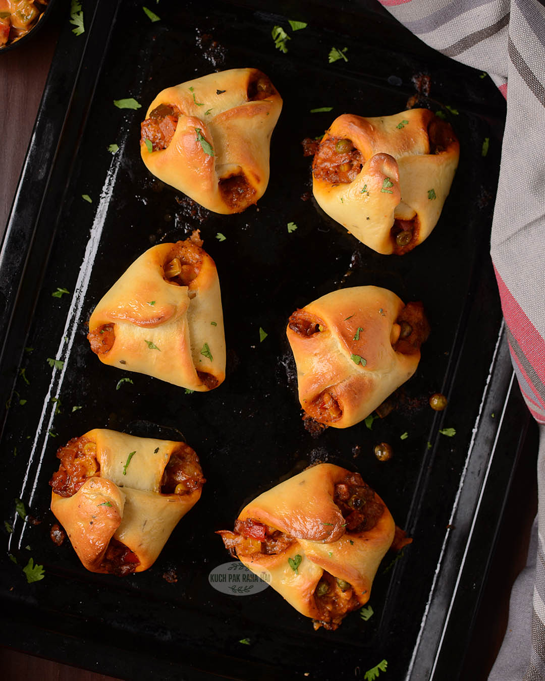 Veggie parcels placed on black baking tray.