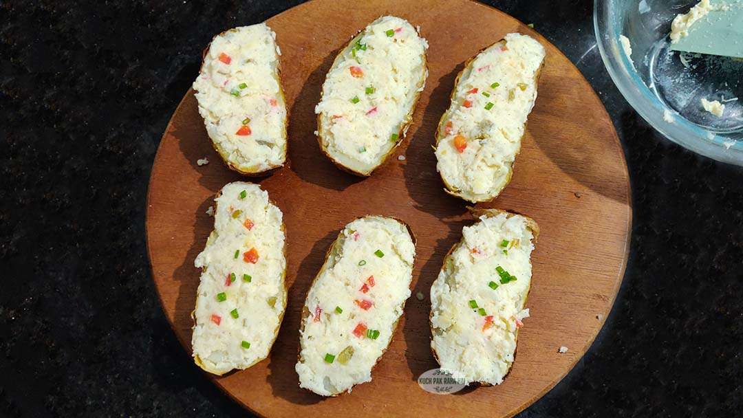 Stuffing potato mash in hollowed potato skins.