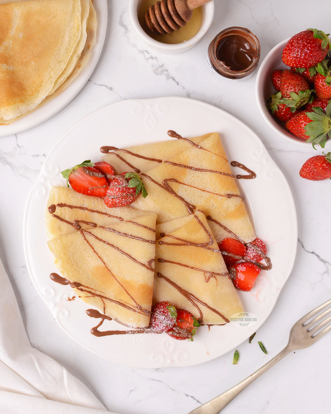 Egg free crepes served with nutella and sliced strawberries.