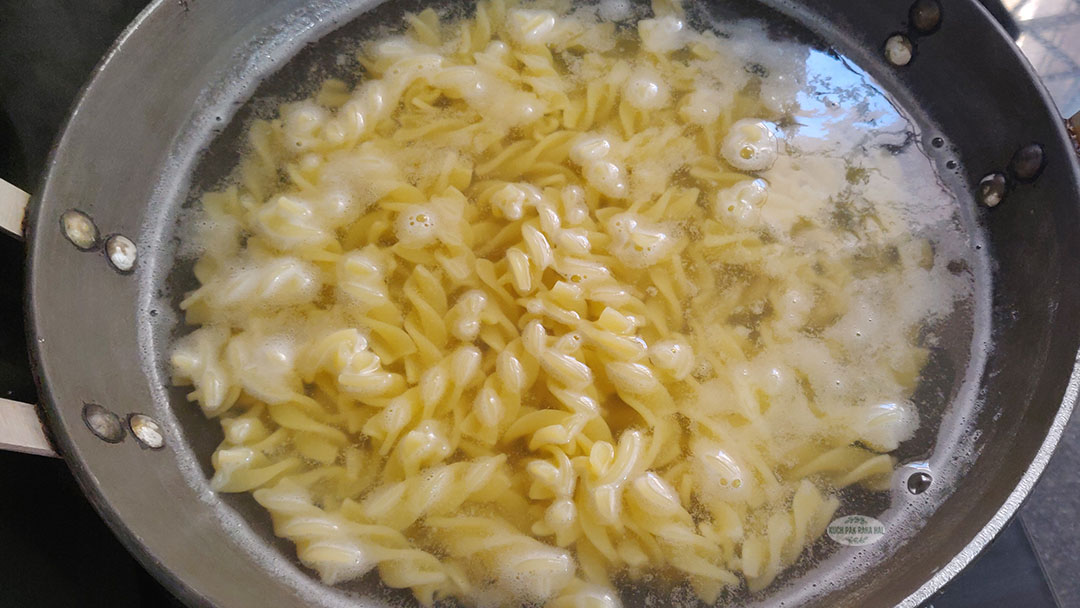 Boiling pasta in a pot on stovetop.