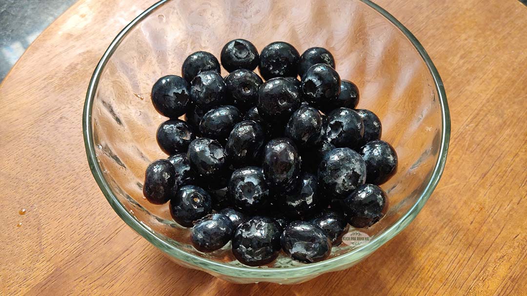 Mixing blueberries with lemon juice and powdered sugar.