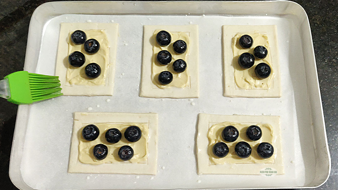 Brushing milk on puff pastry.