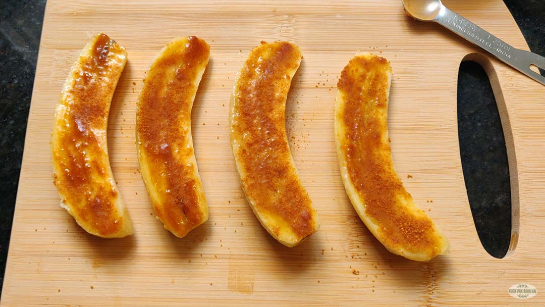 Sprinkling sugar and cinnamon on bananas.