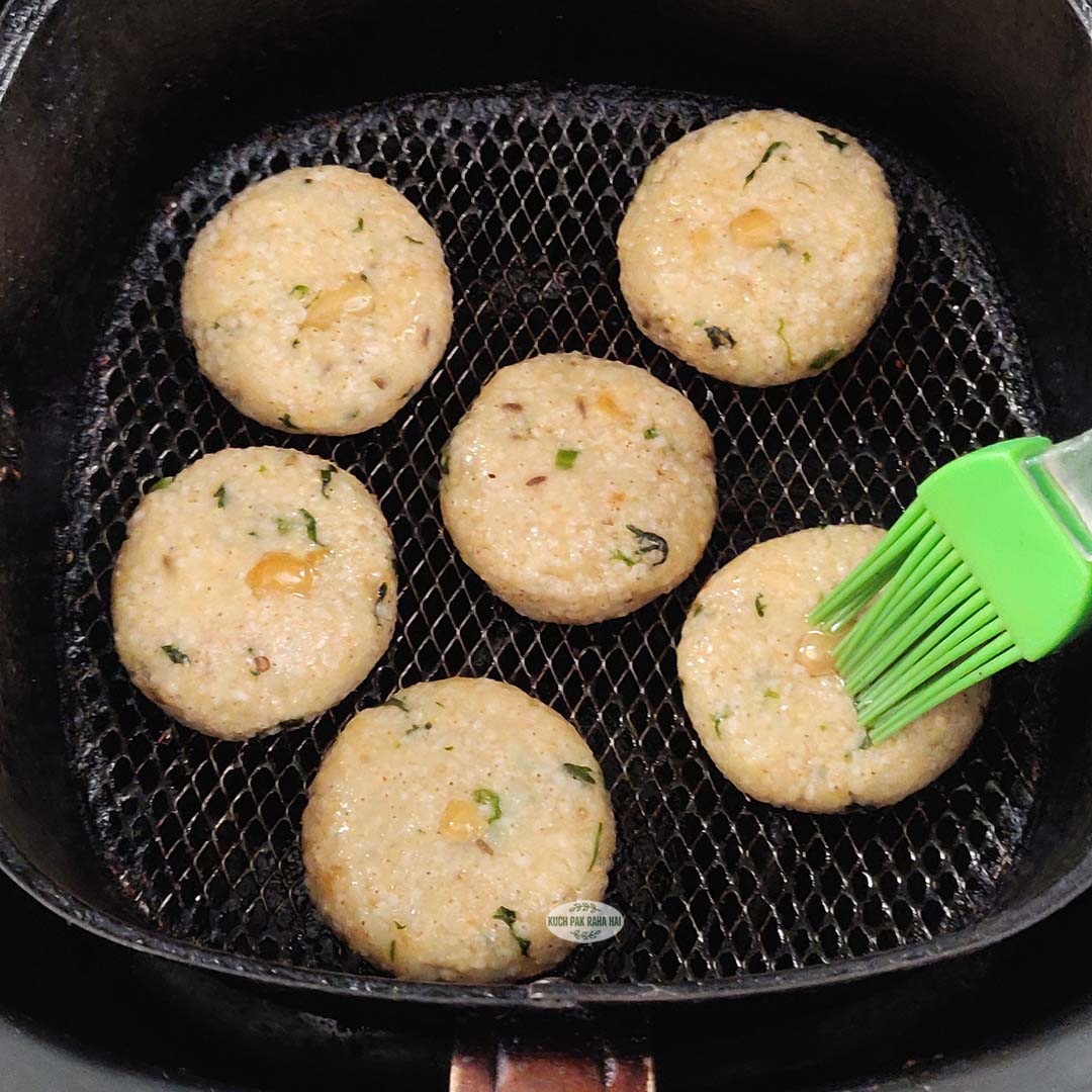 Brushing oil on sama cutlets before air frying.