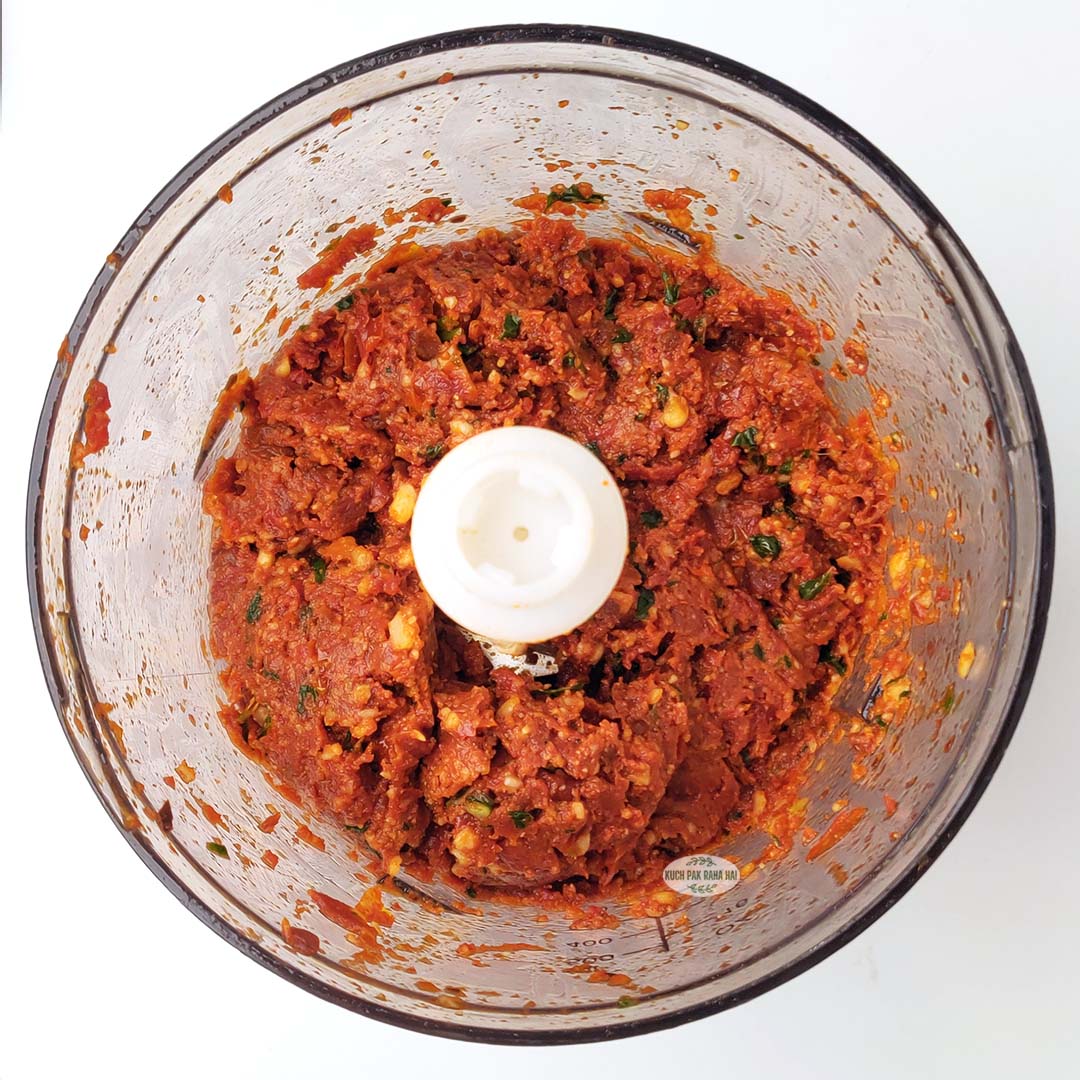 Blending ingredients to make tomato pesto.