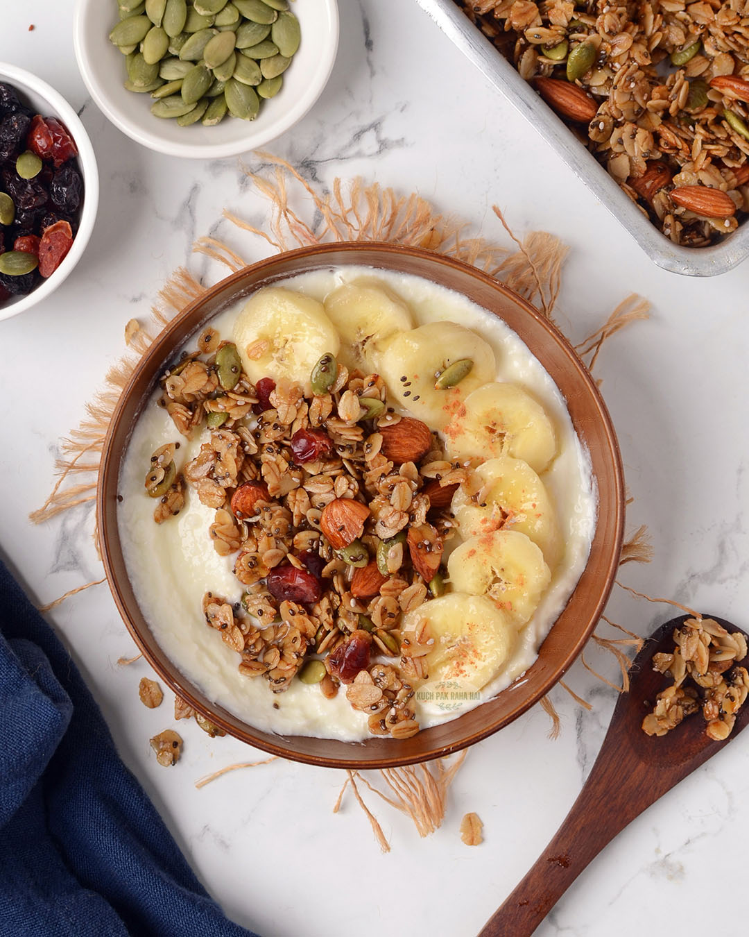 Granola served with greek yoghurt & bananas in a bowl.