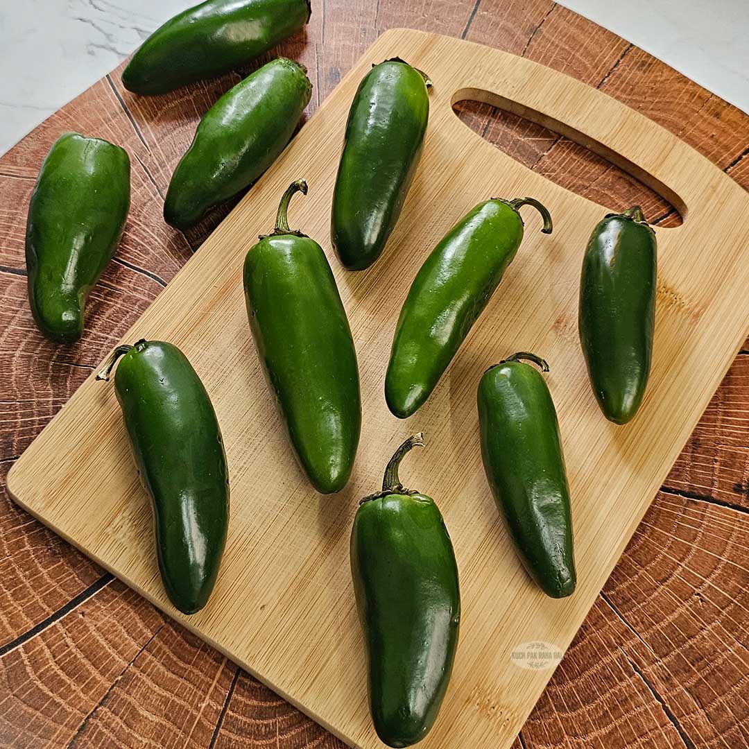Fresh jalapenos on chopping board.