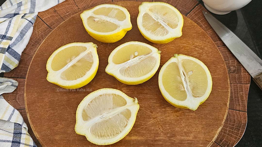 Halved lemons on chopping board.