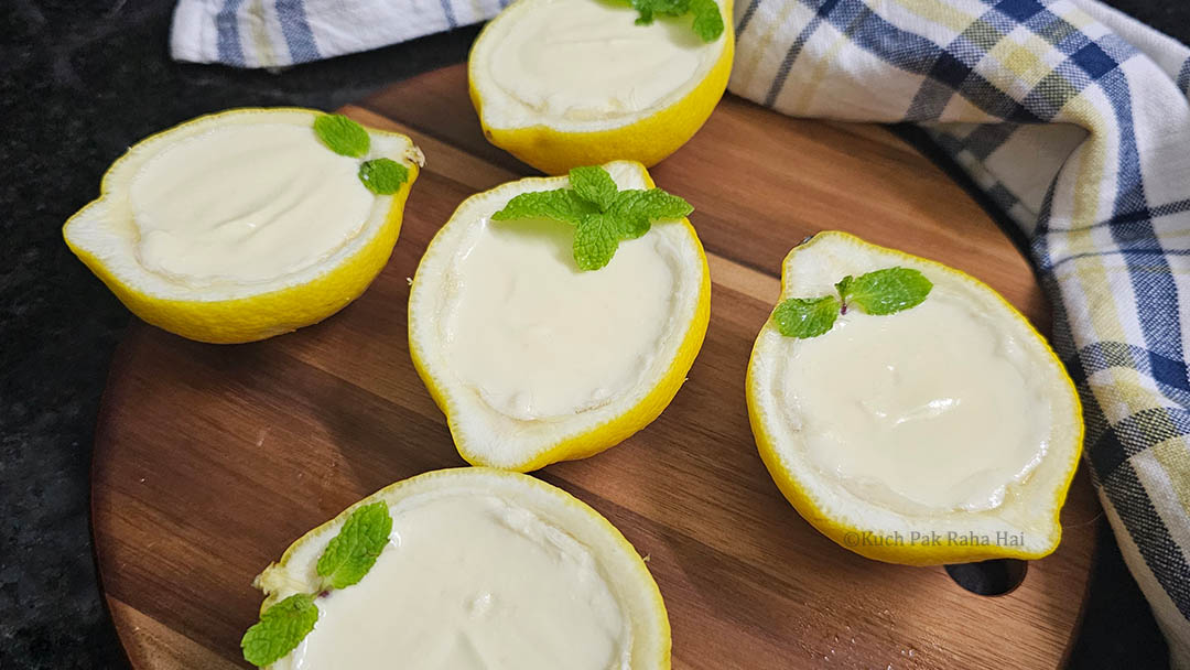 Garnishing lemon possets with mint leaves.